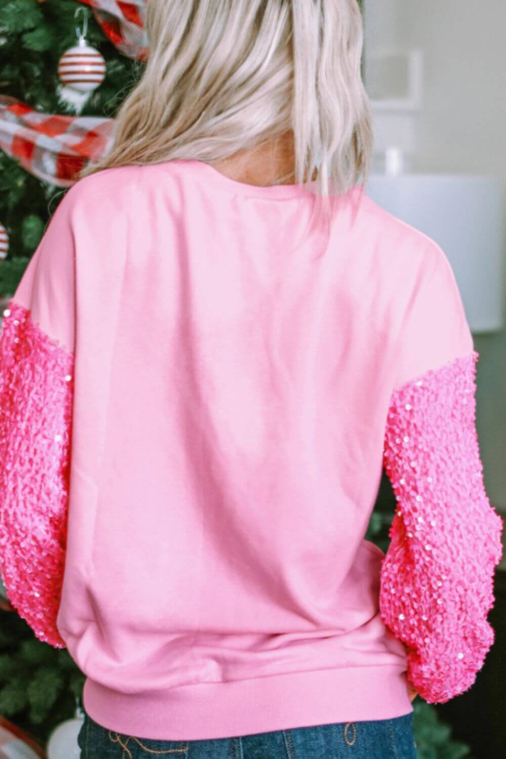 Back view of Sequin Heart Sweatshirt featuring pink sequined sleeves and cozy fit for a stylish look.