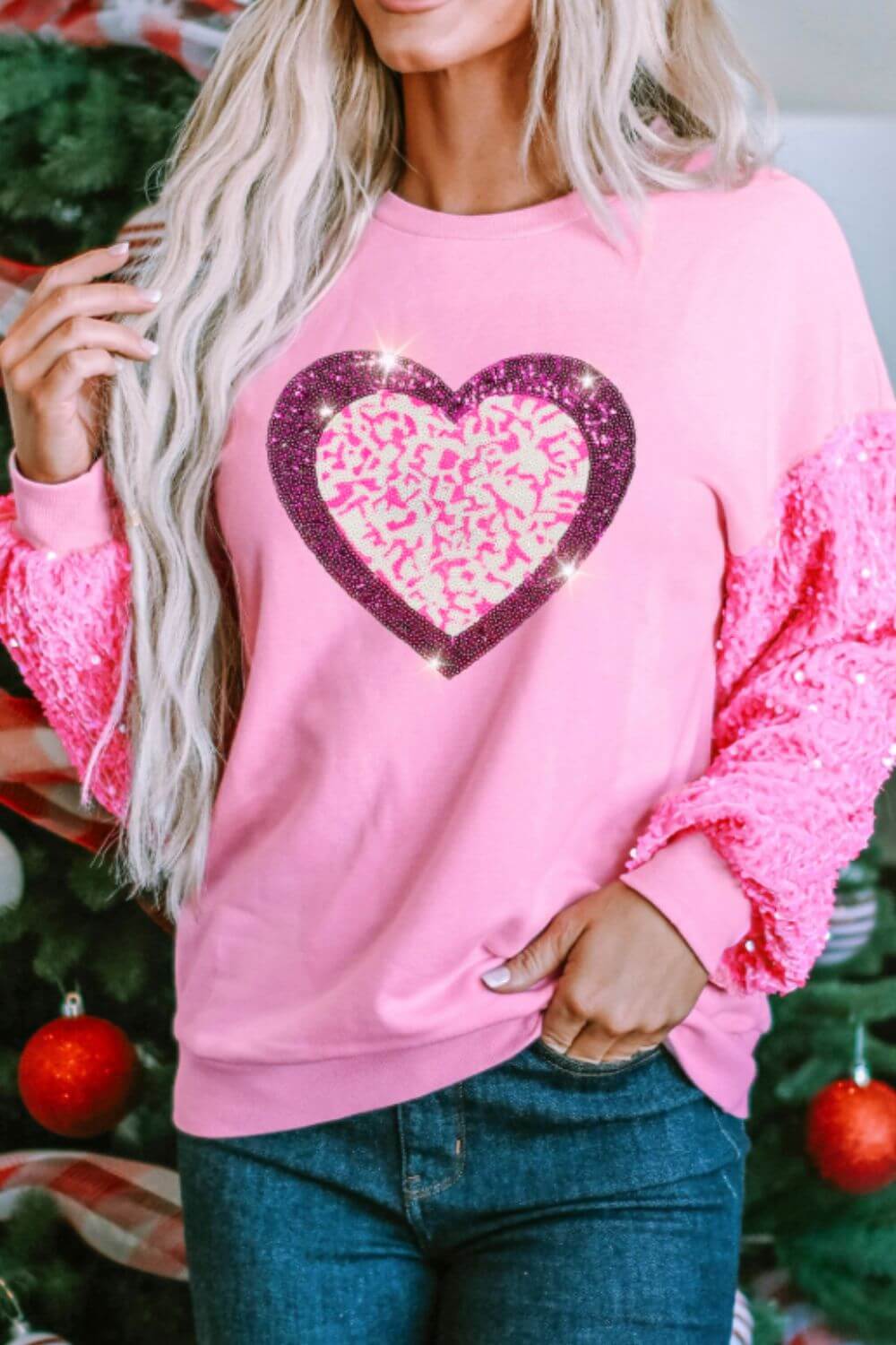 Sequin Heart Sweatshirt featuring a pink design with a sparkling heart, styled for cozy and festive occasions.