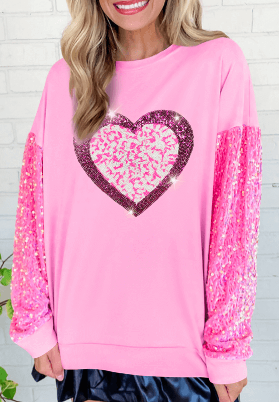 Sequin Heart Sweatshirt in pink with a sparkling heart design and sequin sleeves, perfect for cozy and festive occasions.