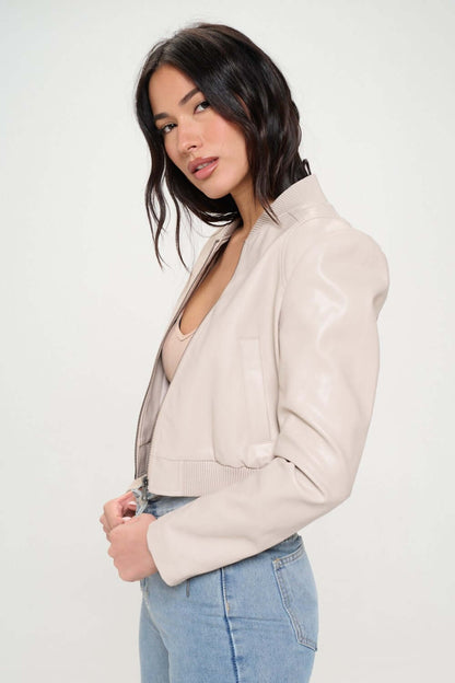 Female model wearing Coalition LA vegan leather cropped bomber jacket cream